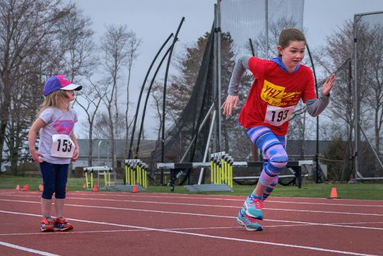 two young girls running on a track